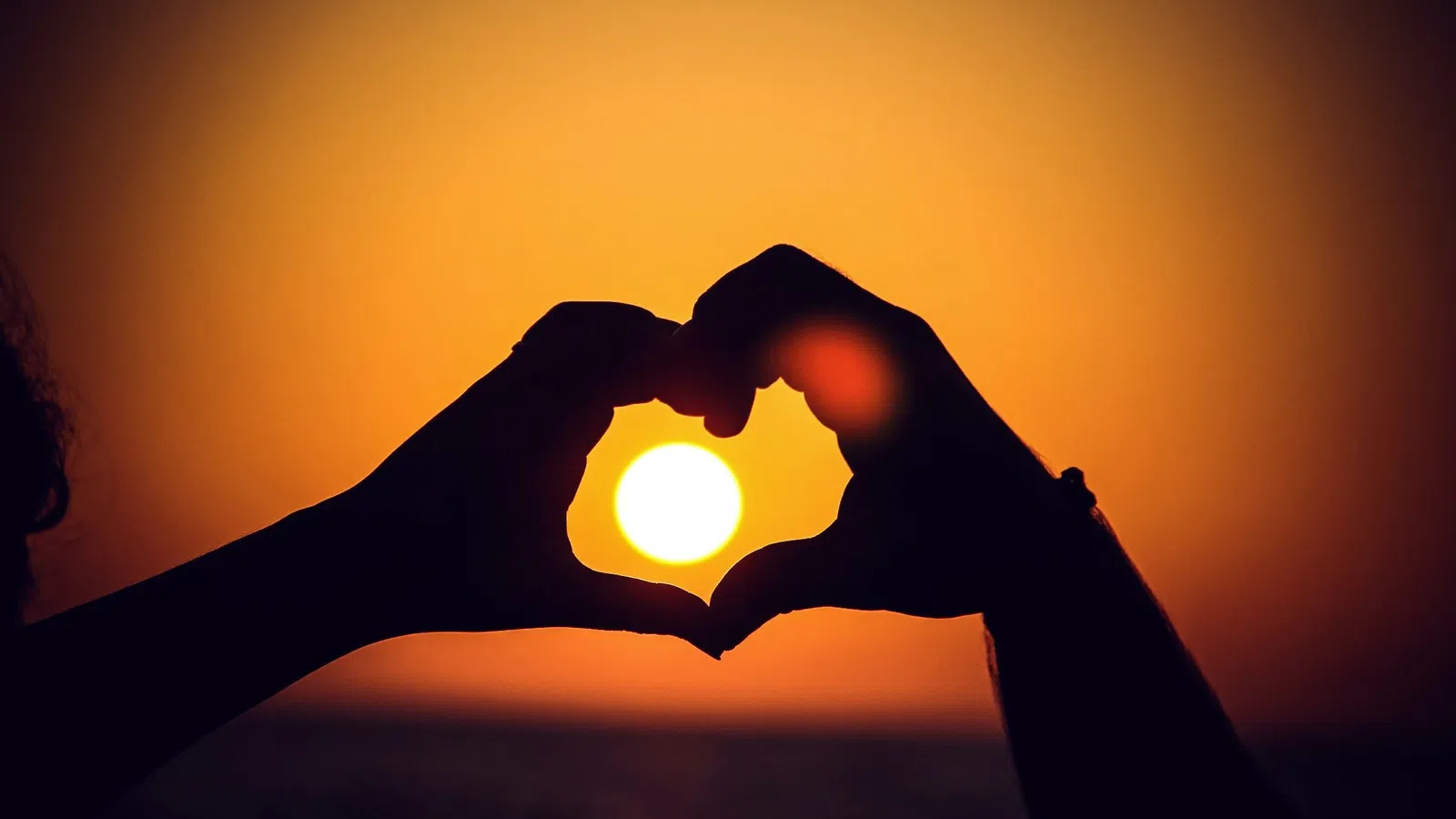 a person holding their hand up to the sun