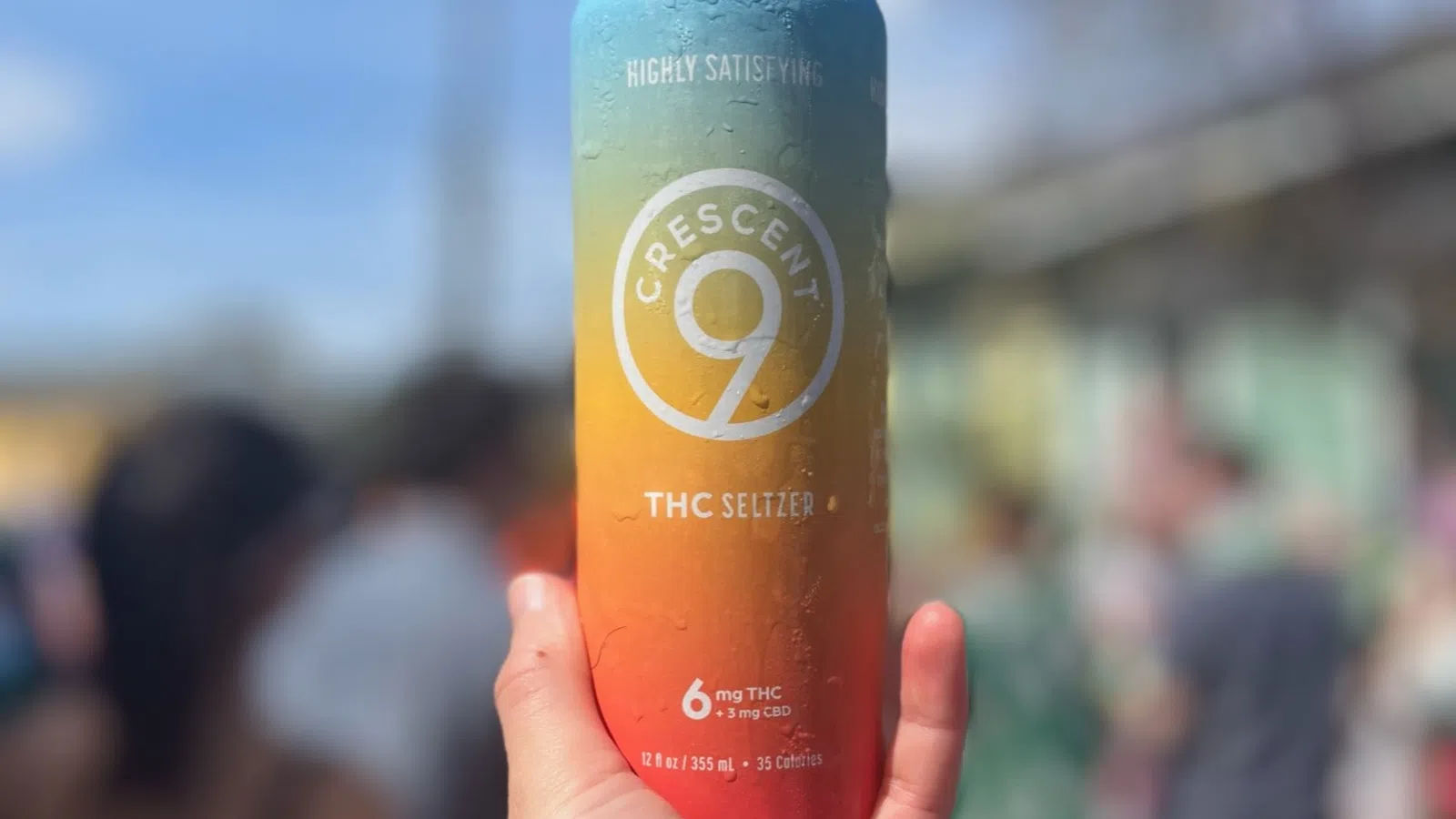 a hand holding a can of beer