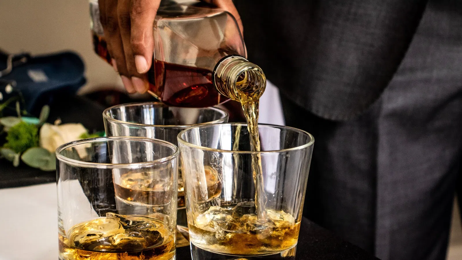 a person pouring wine into glasses