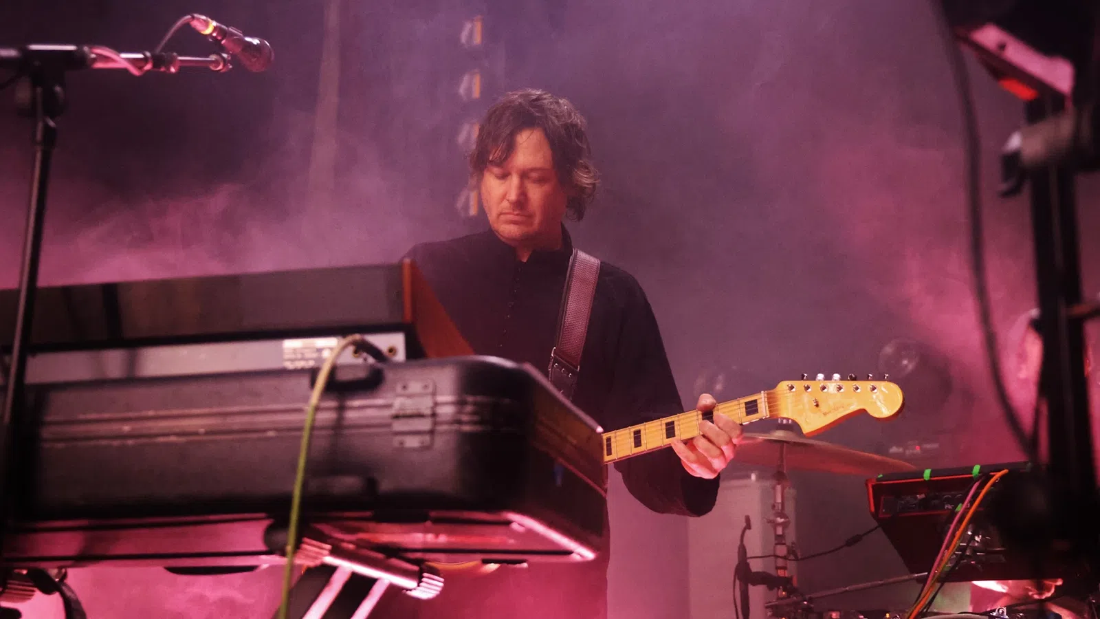 a man playing a guitar on a stage