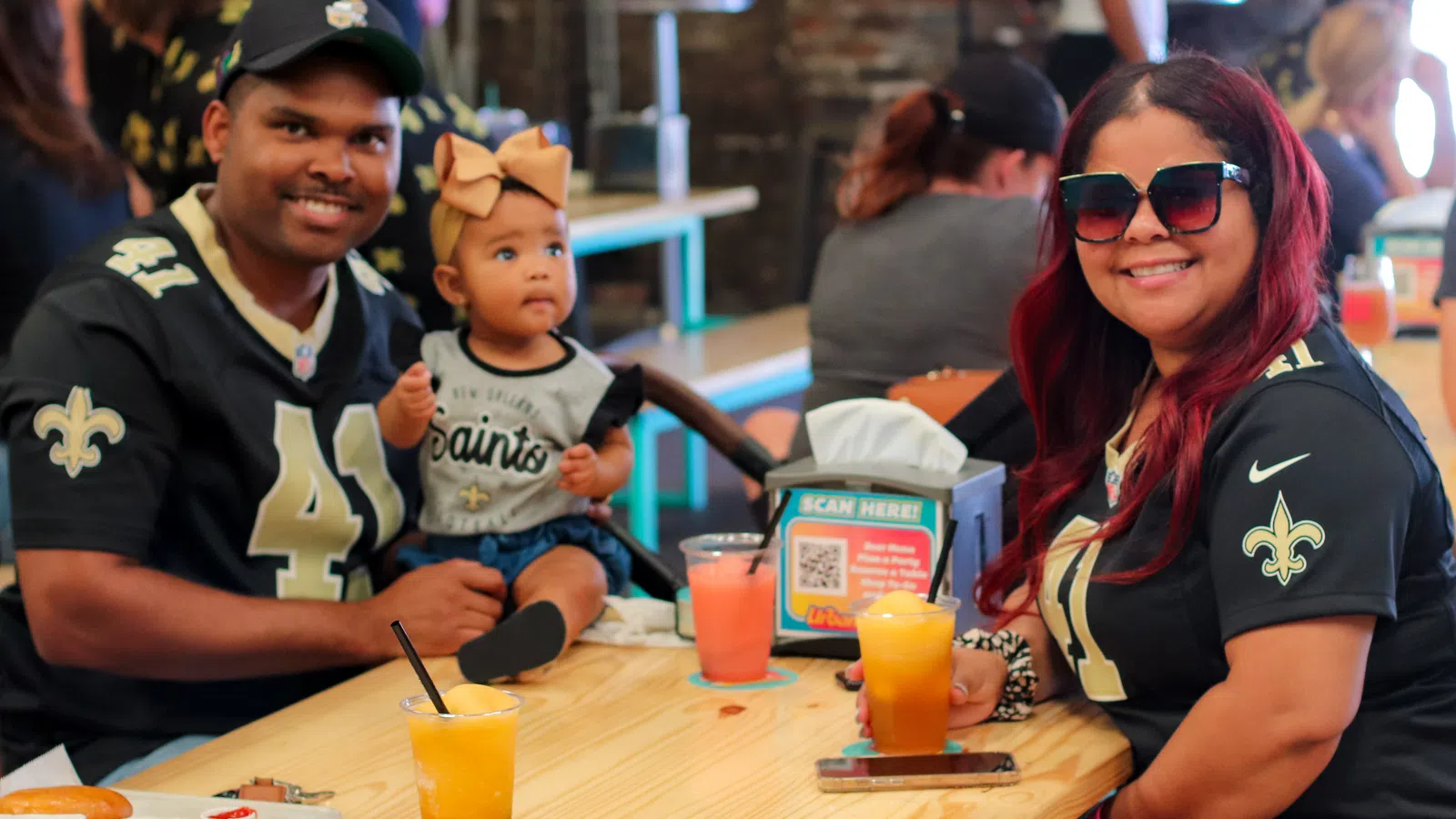 a group of people sitting at a table with food and drinks