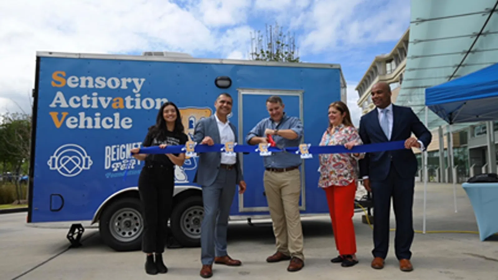 a group of people standing in front of a blue truck