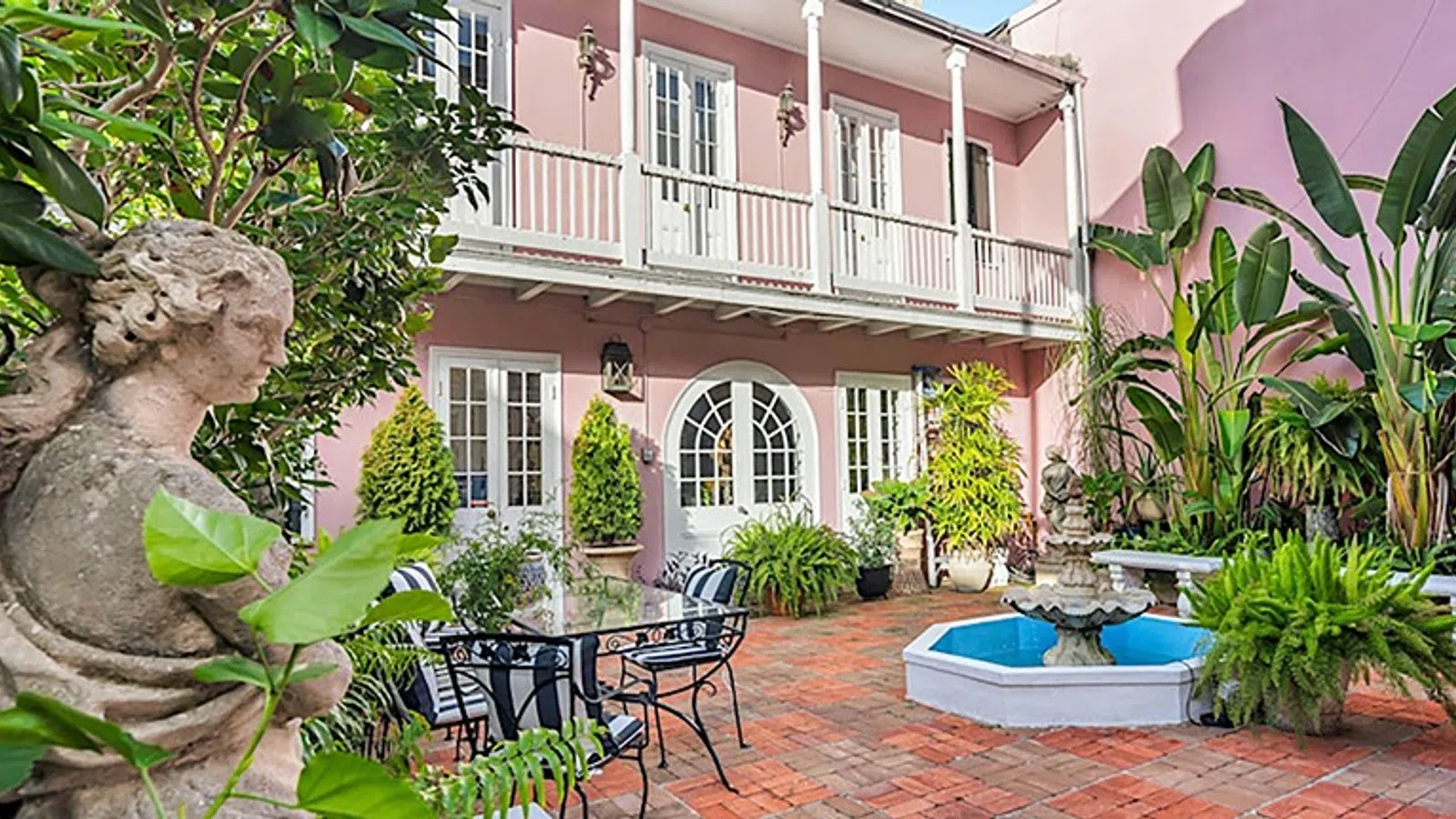 a courtyard with a fountain and chairs