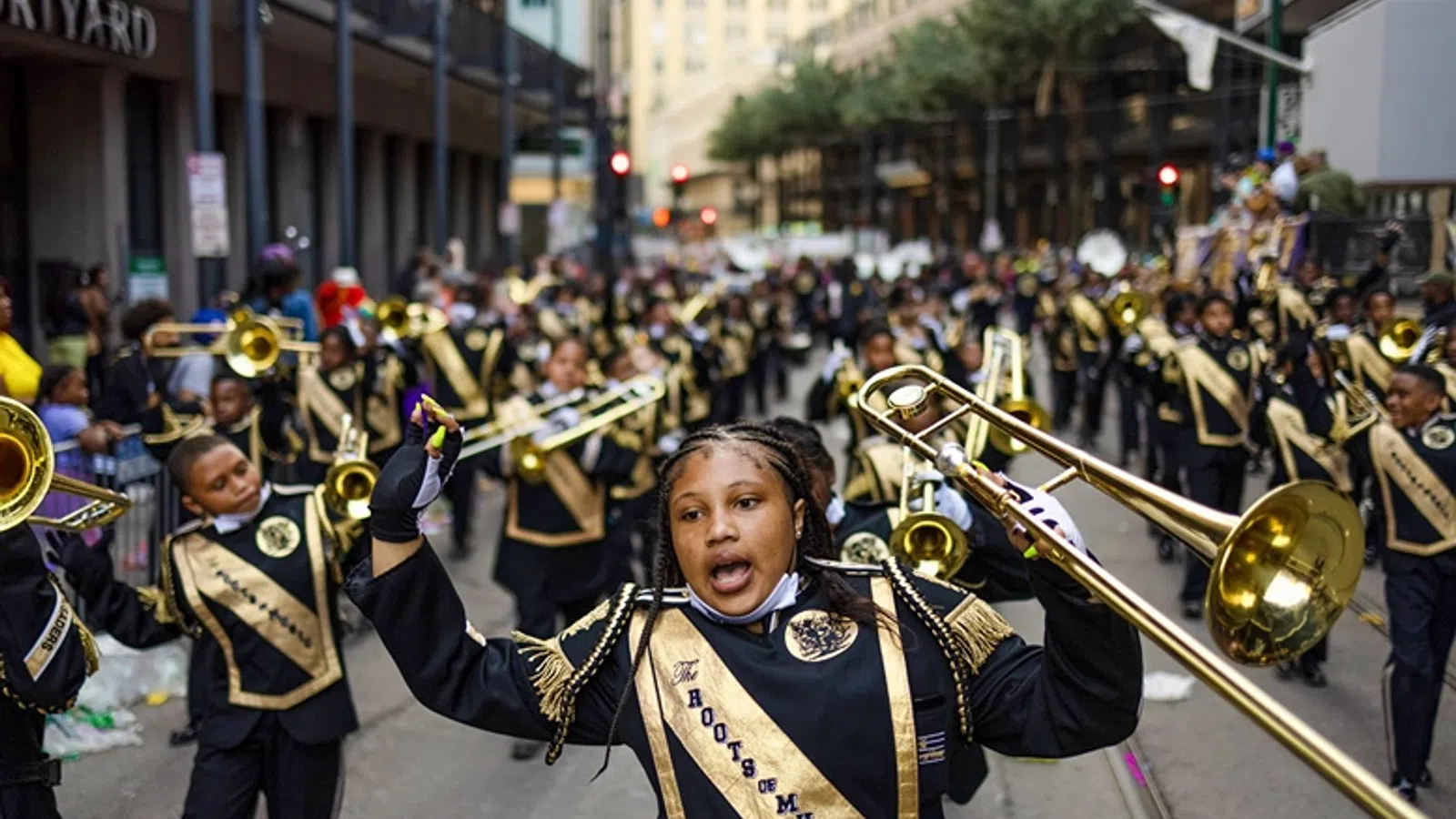 a person holding a brass instrument in front of a crowd of people