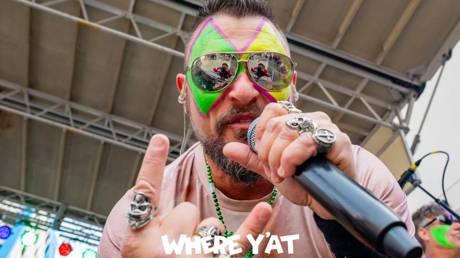 a person with colorful hair and sunglasses holding a microphone