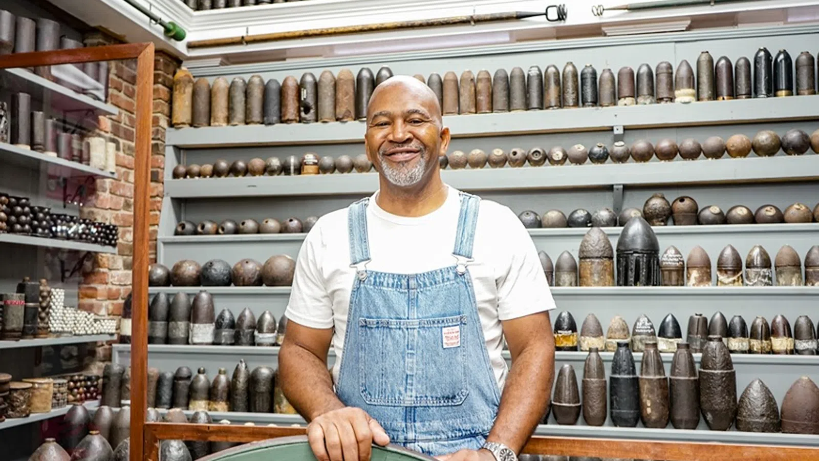 a man standing in front of a shelf of jars