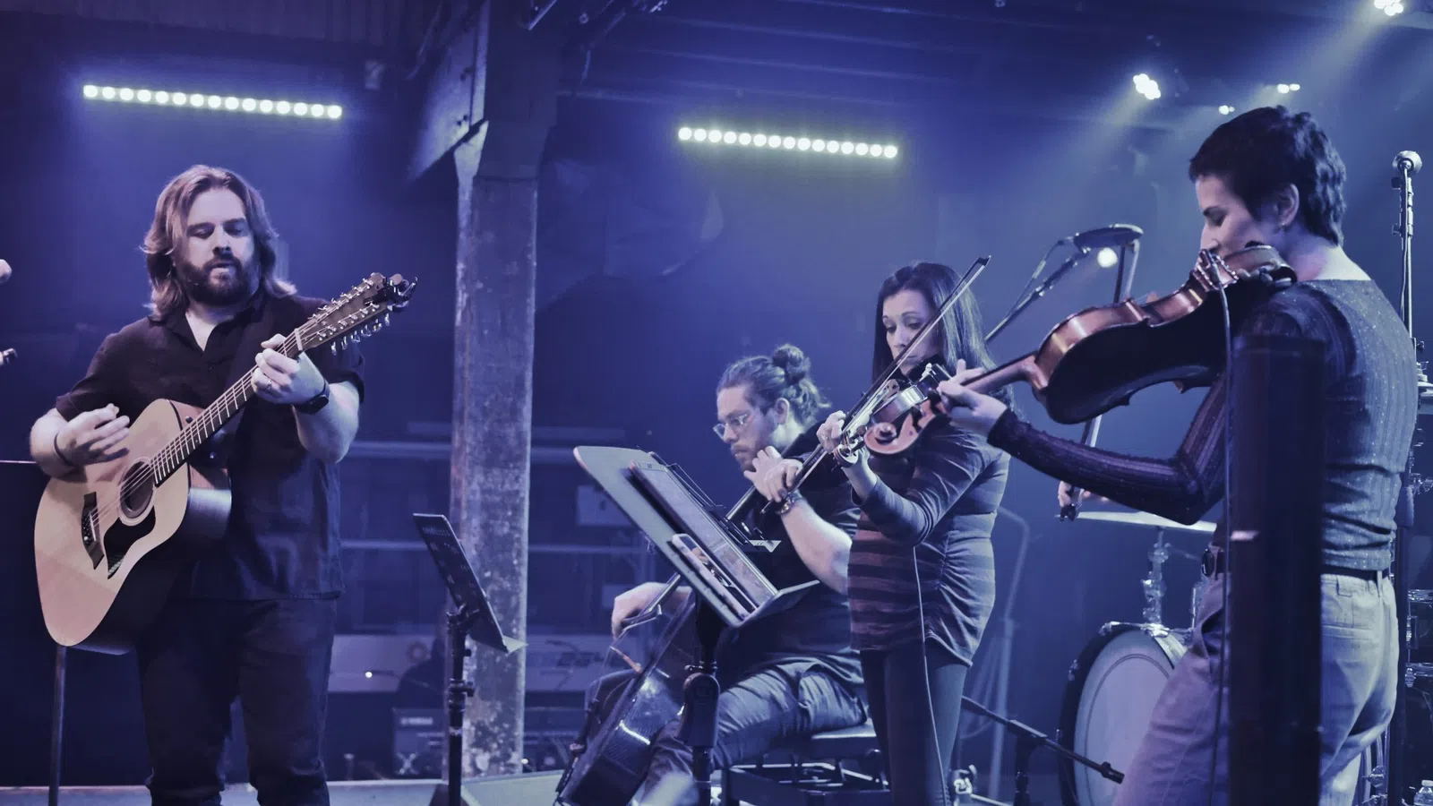 a group of people playing instruments on a stage
