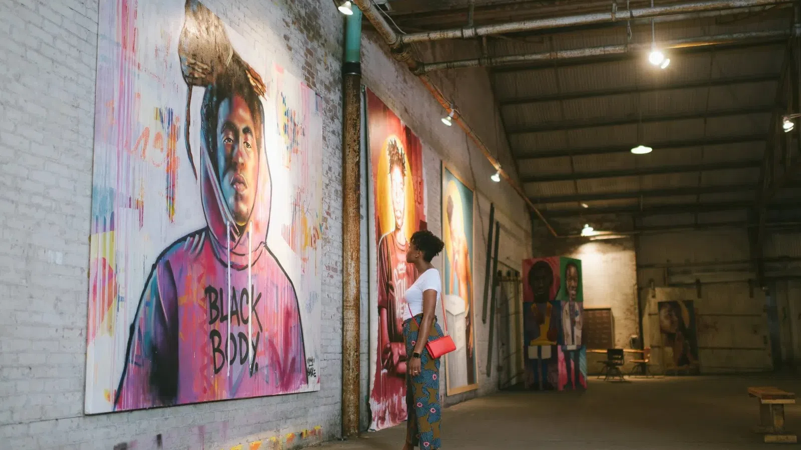a person standing next to a wall with art on it