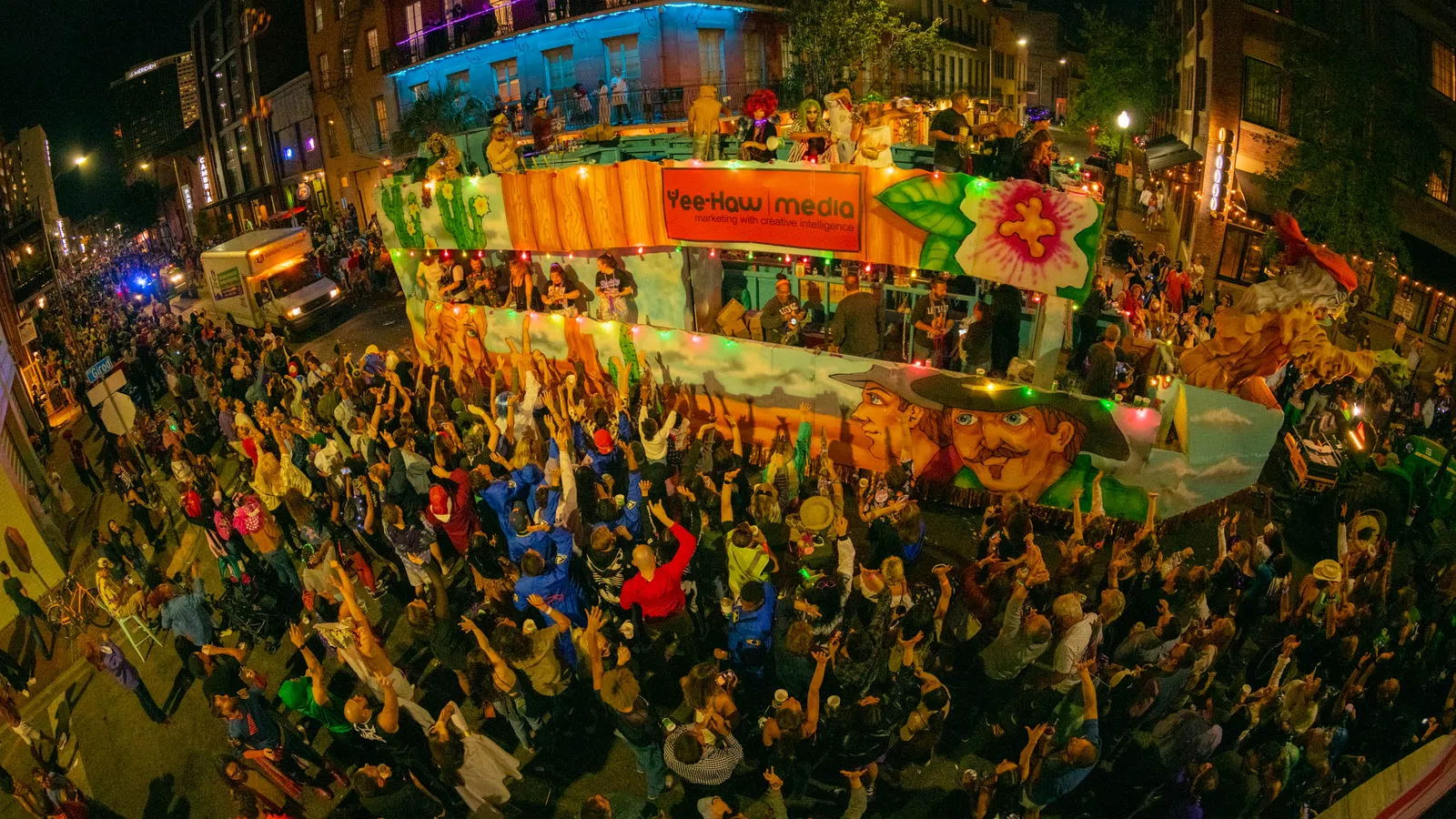 Night parade with vibrant float painted with colorful faces and lively crowd enjoying the festive street event