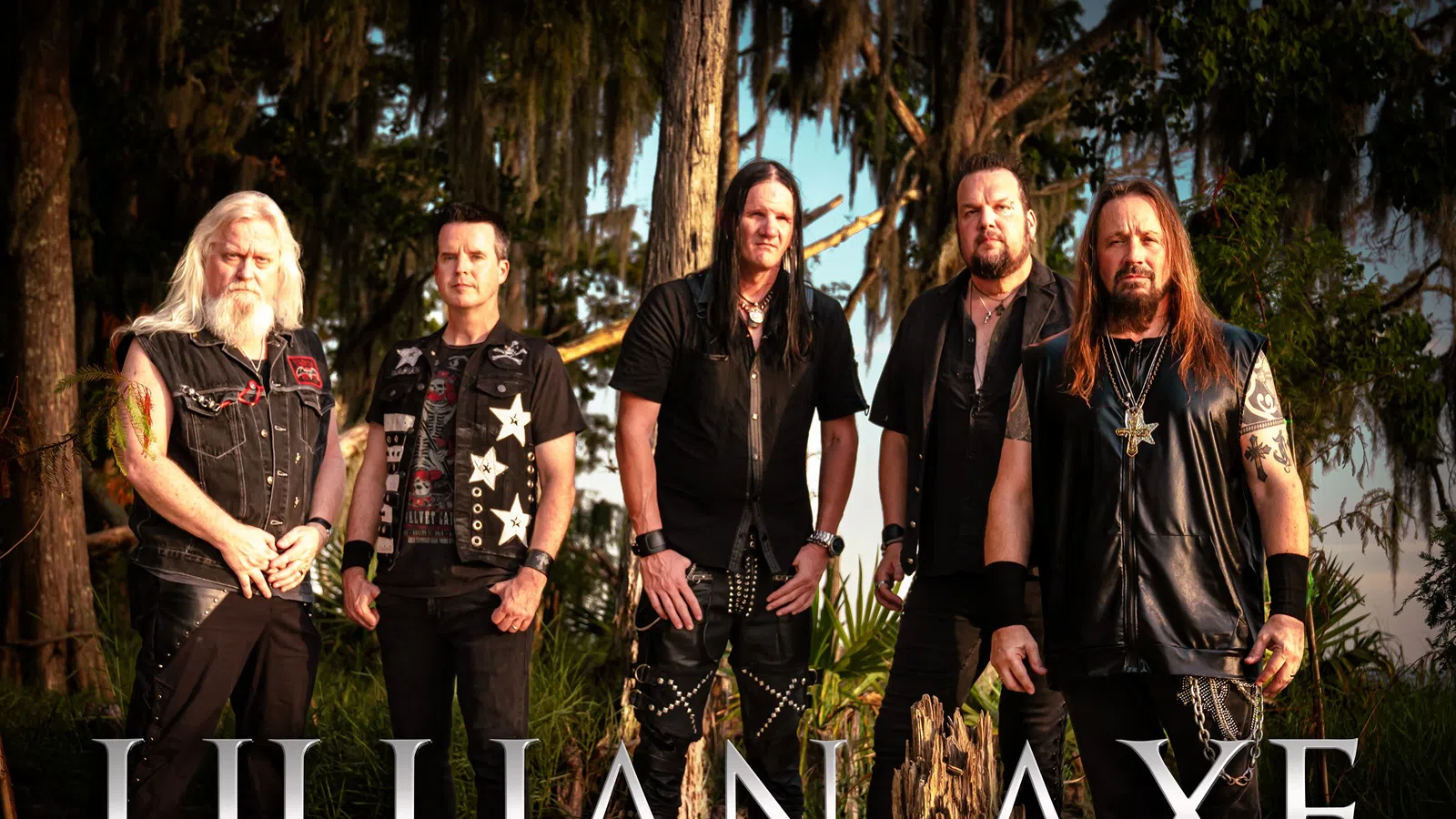 Five members of the heavy metal band Lillian Axe posing outdoors with trees in the background and band name overlay.