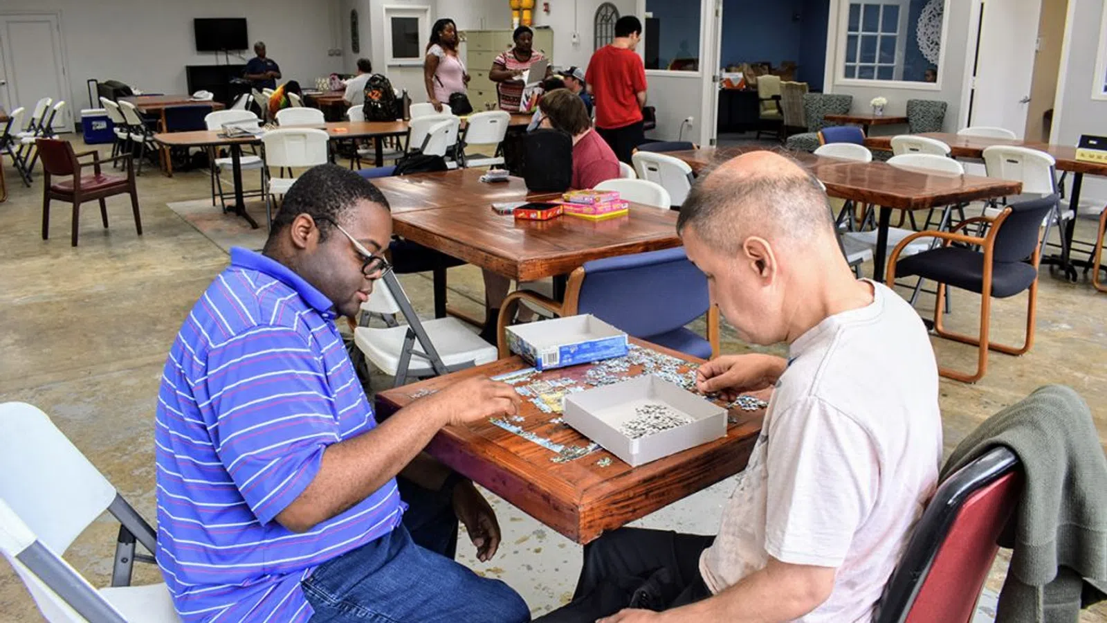 a couple of men sitting at a table playing a board game