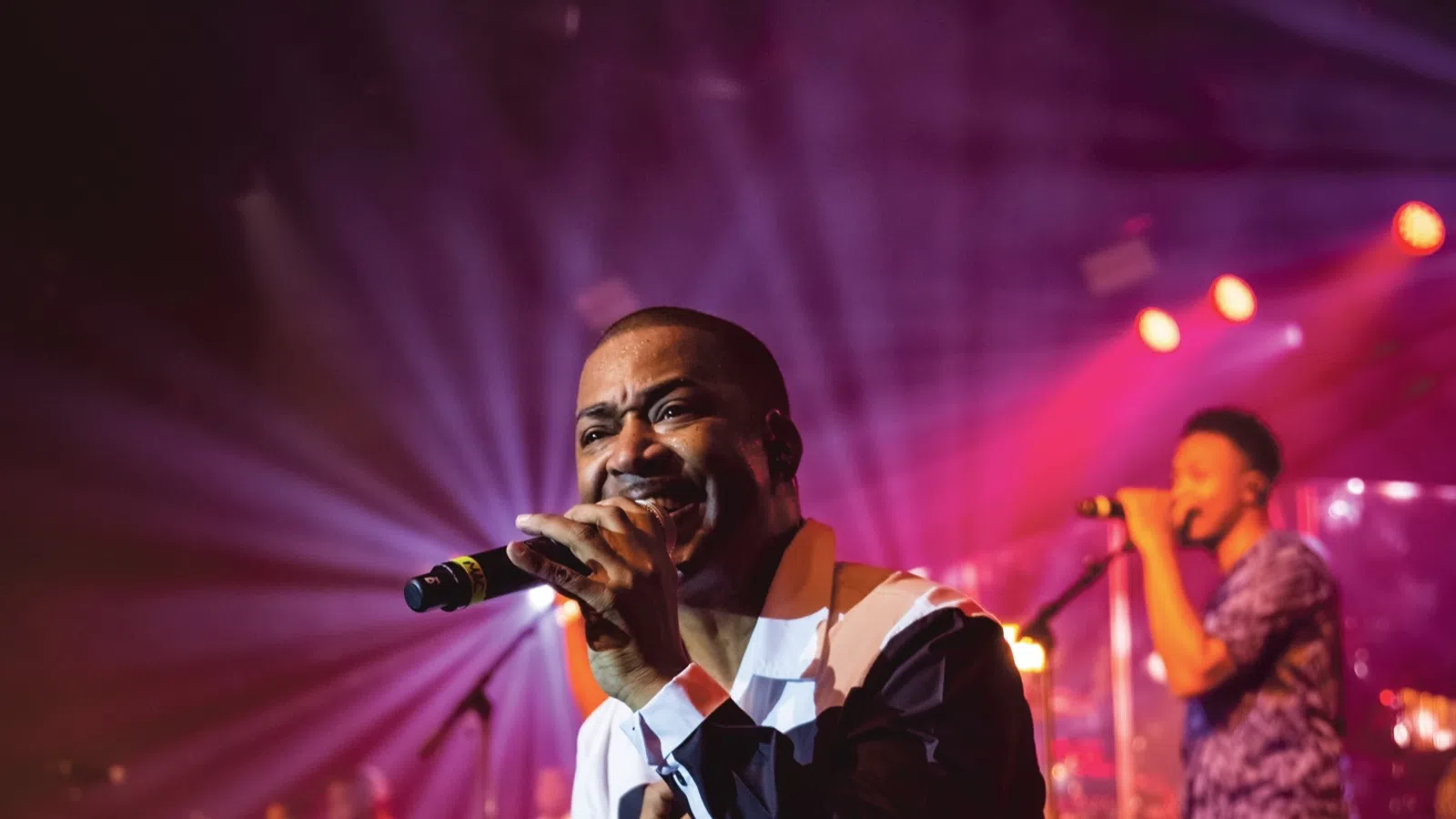 a person singing into a microphone on a stage