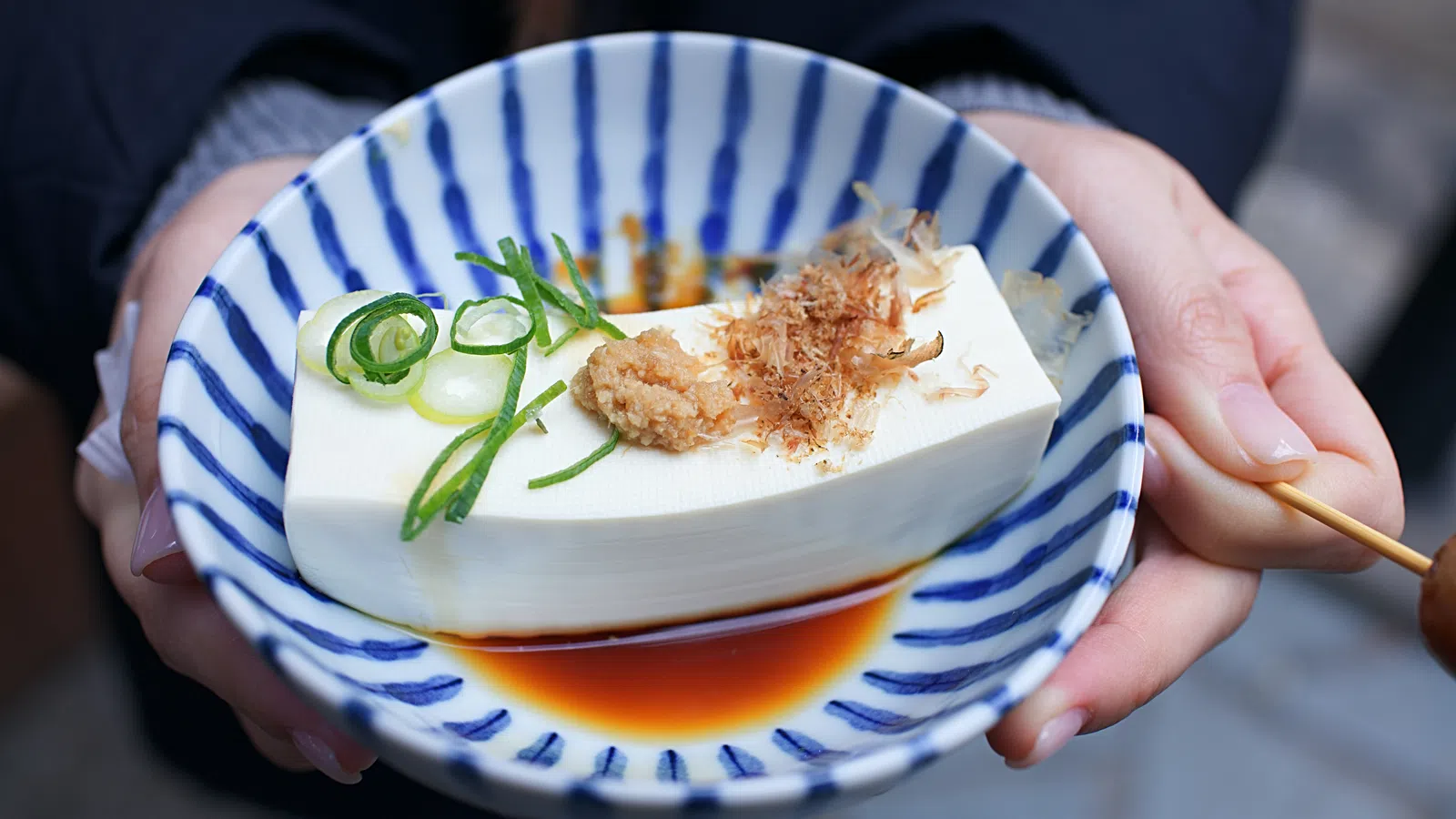 a person holding a bowl of food