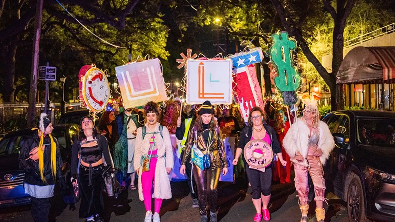 a group of people walking down a street with signs and flags