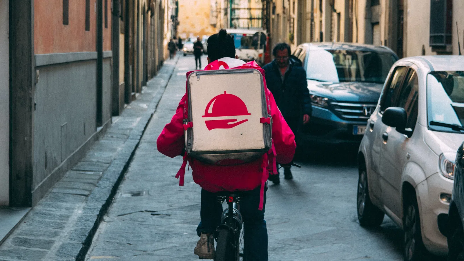 a person on a bicycle with a person in a garment on the back