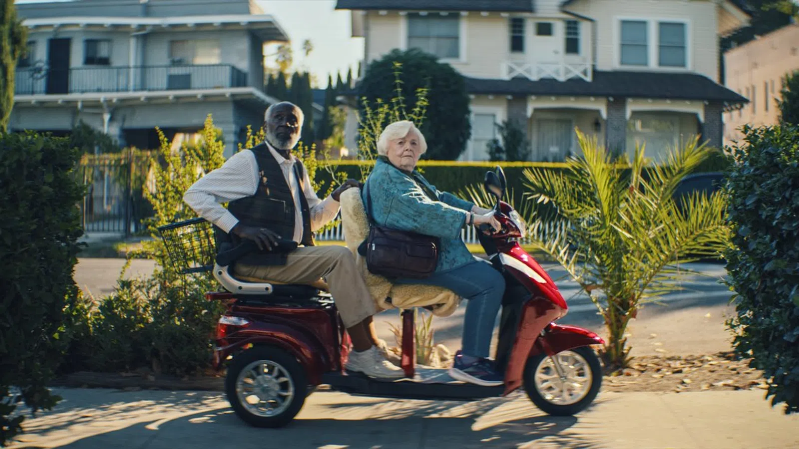 a man and woman riding a scooter