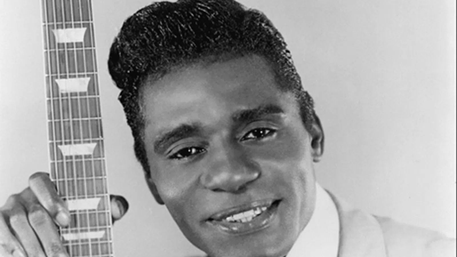 Guitar Slim smiling and holding a piece of paper