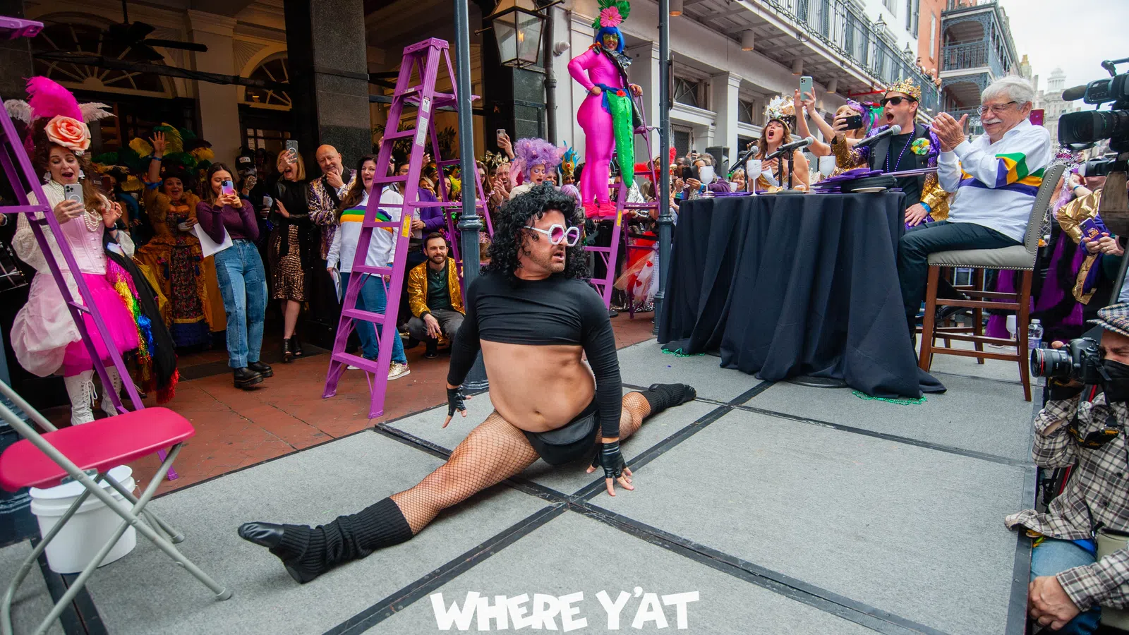a person sitting on a stage with a crowd watching