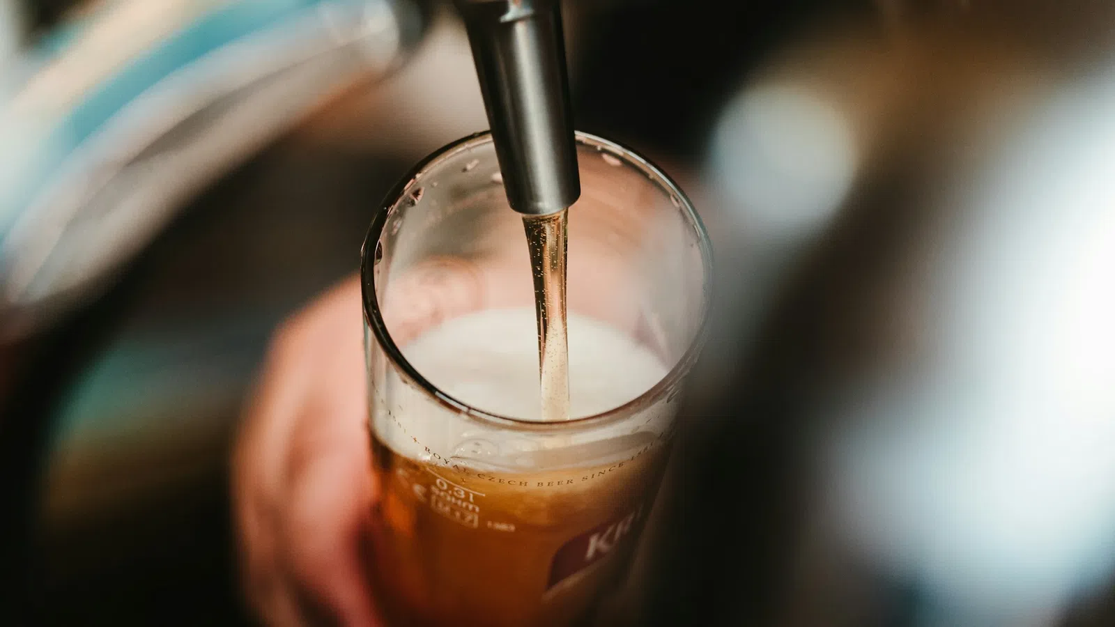 a hand holding a glass of liquid
