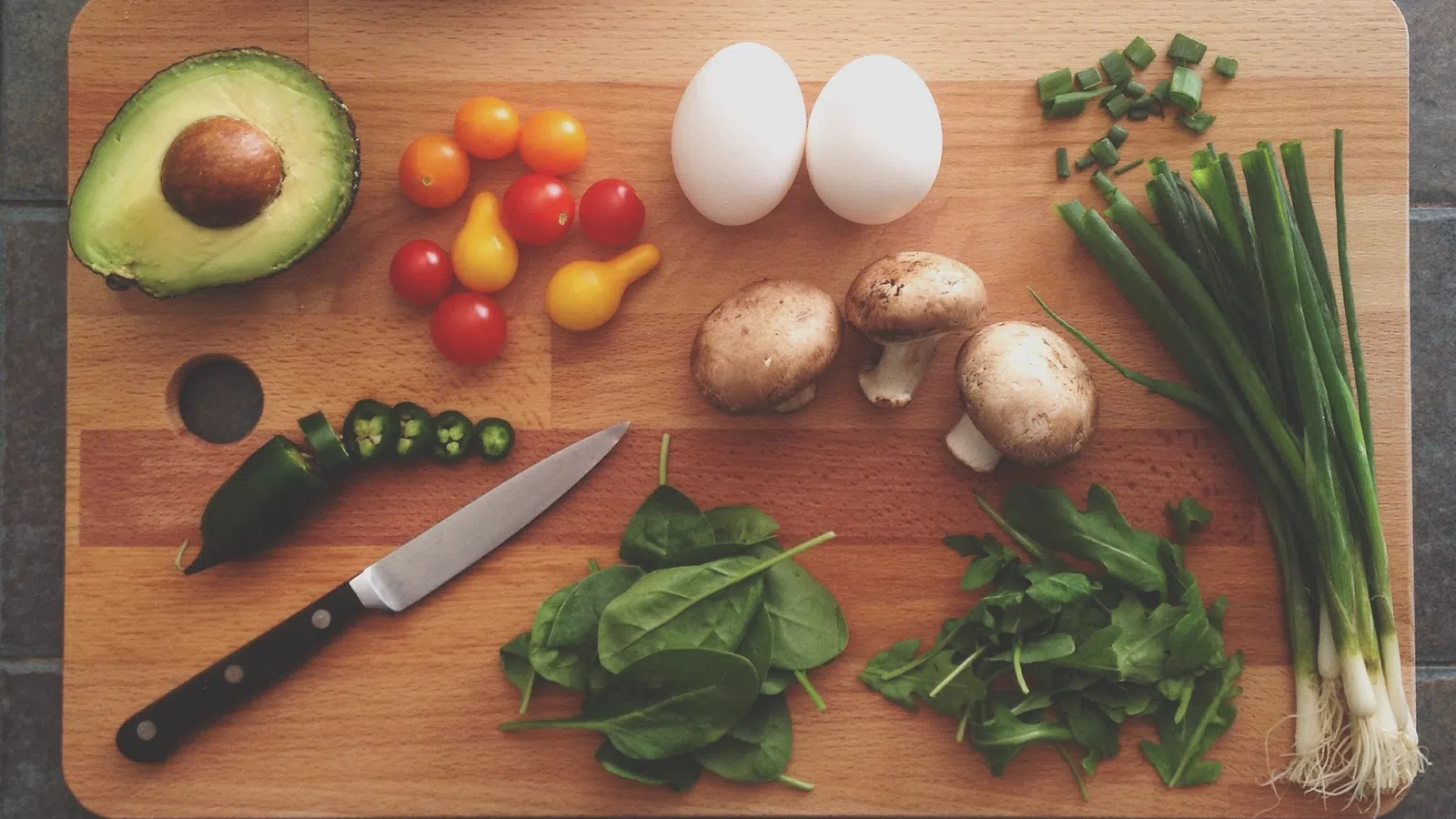 a knife and vegetables on a cutting board