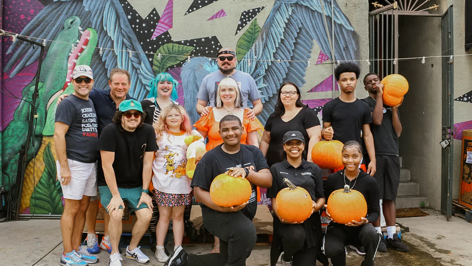 a group of people posing for a photo with pumpkins