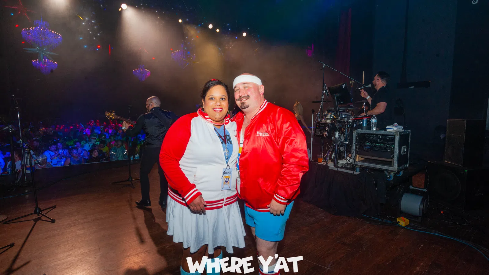 a man and woman posing for a picture in front of a stage
