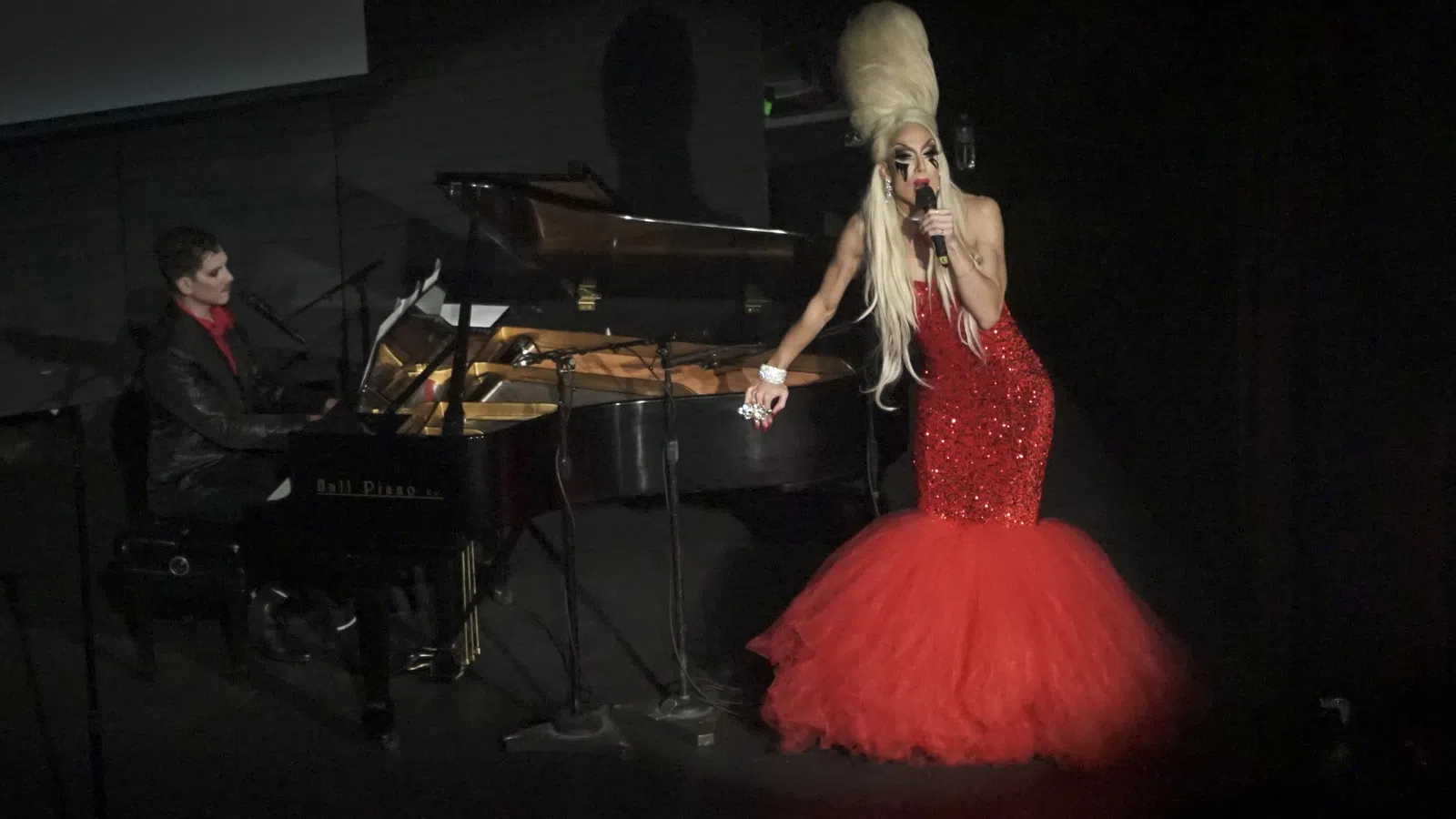 a person in a red dress singing on a stage