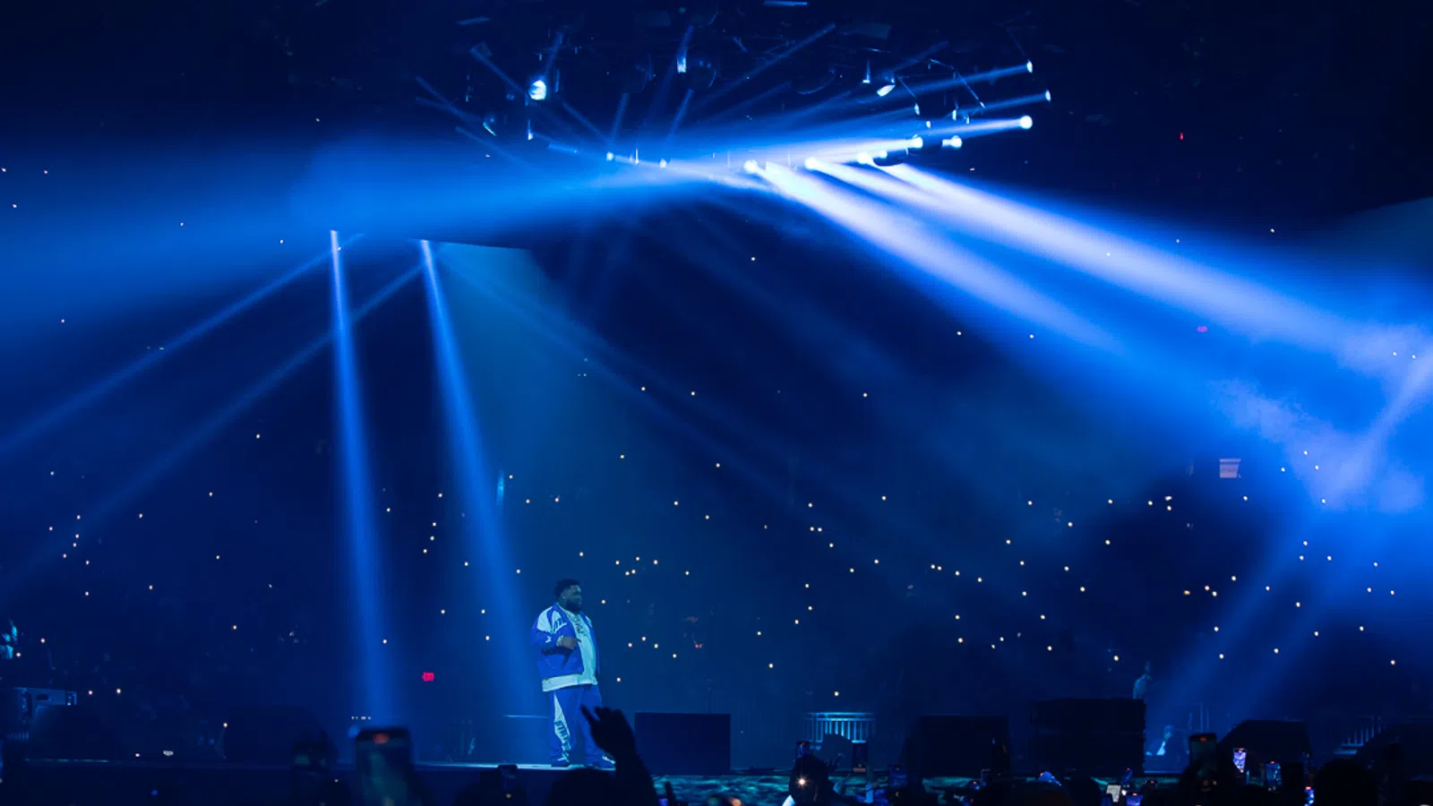 a person on a stage with a crowd watching