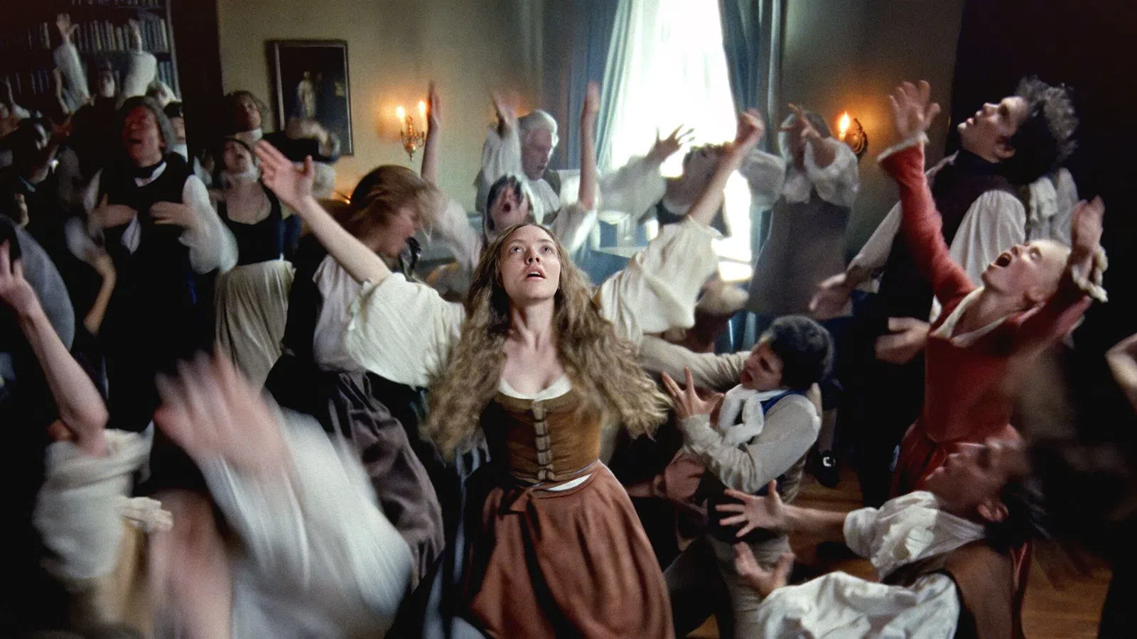 Group of 17th century people in period clothing experiencing a frenzied and dramatic seizure-like dance in a dimly lit room