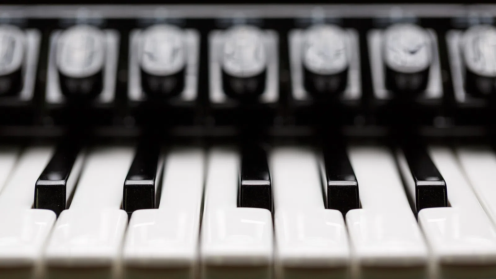 Close-up of piano keys showing white and black keys in sharp focus with blurred background.