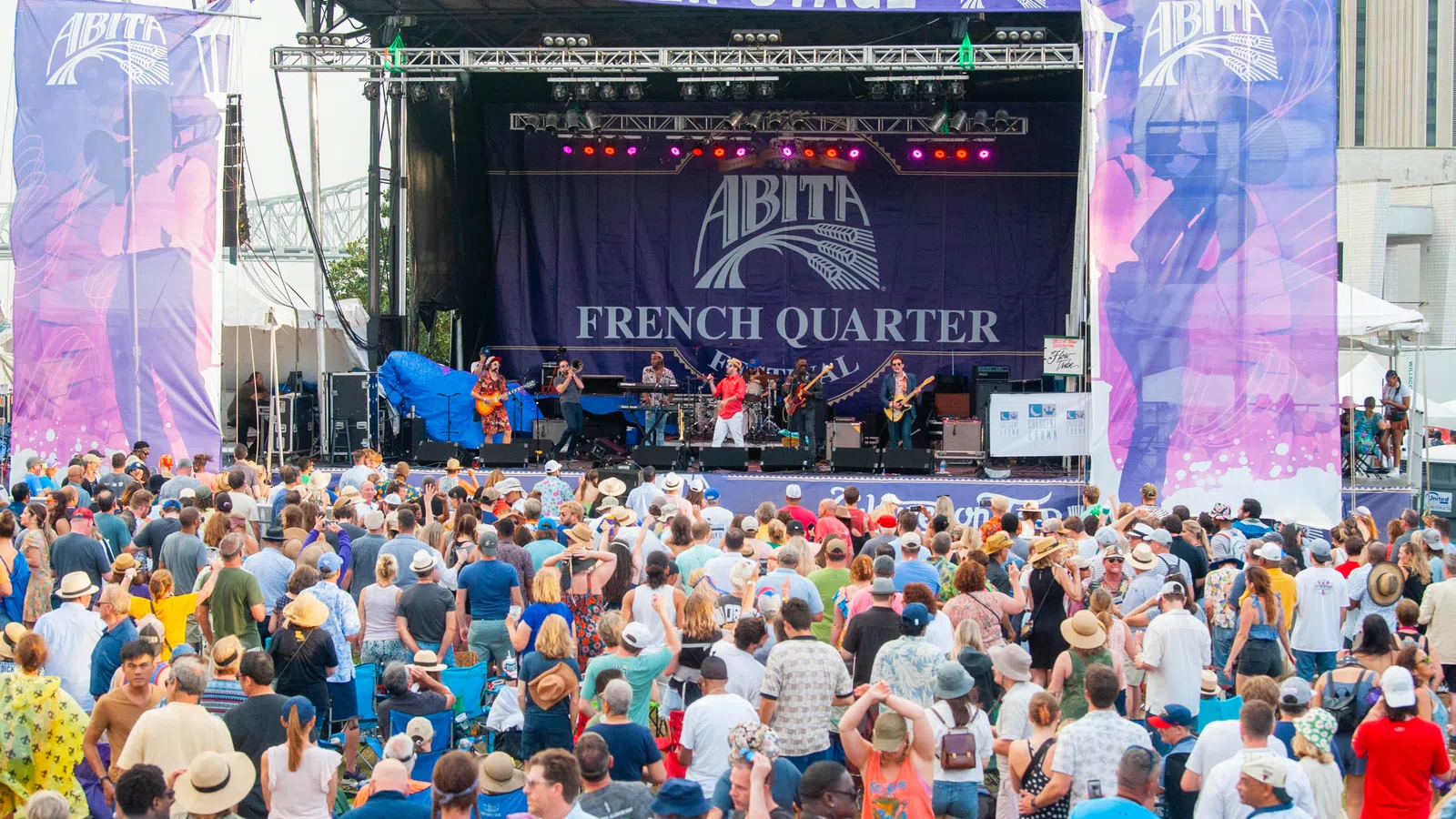 Large crowd enjoying live band performance on Abita Beer Stage at French Quarter Festival outdoors in daytime