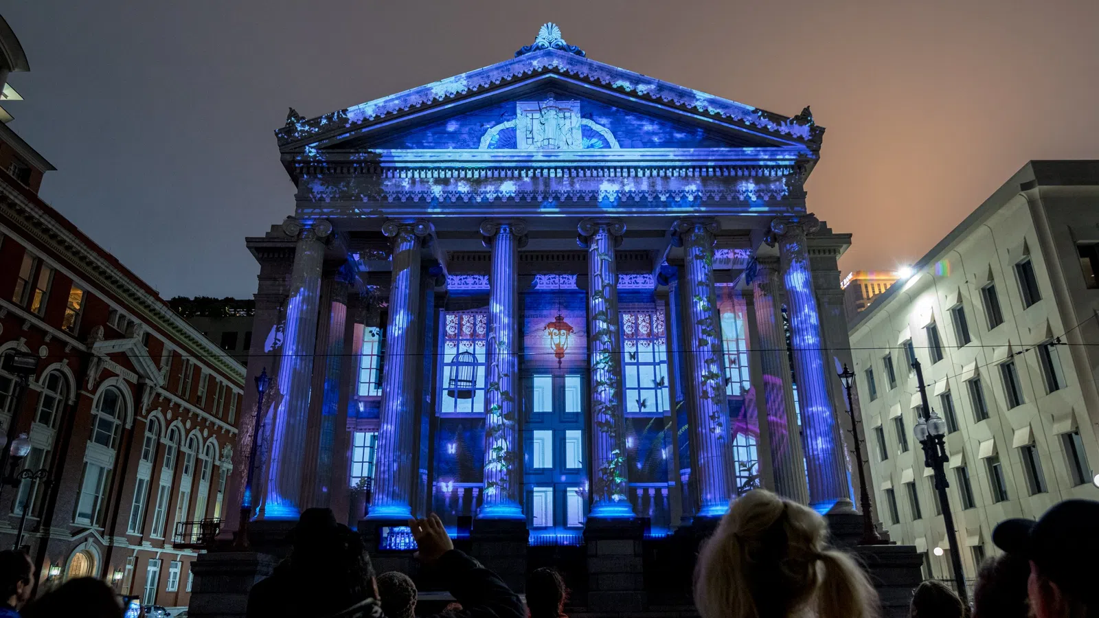 a crowd of people in front of a building with lights