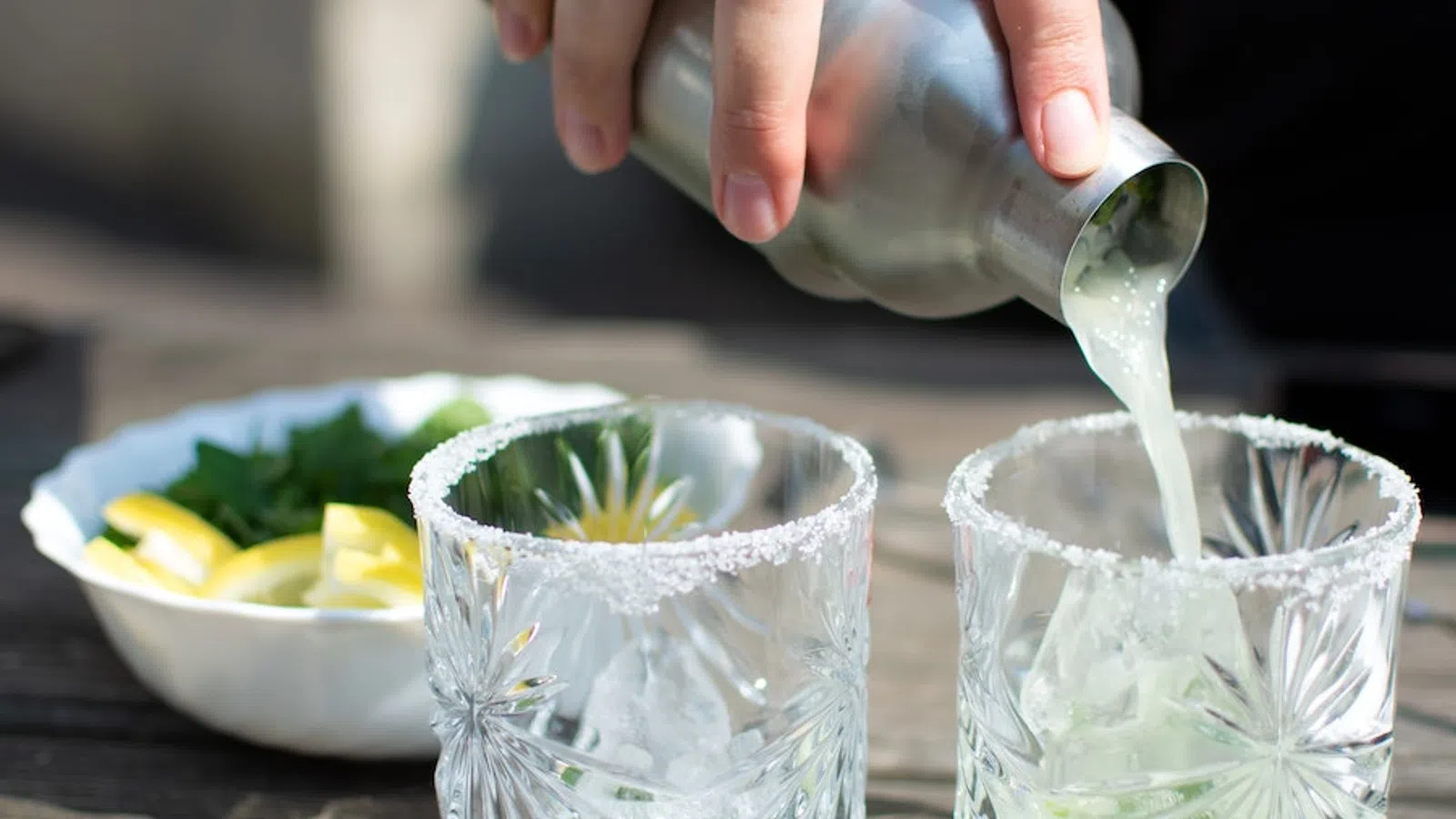 a person pouring a liquid into a glass