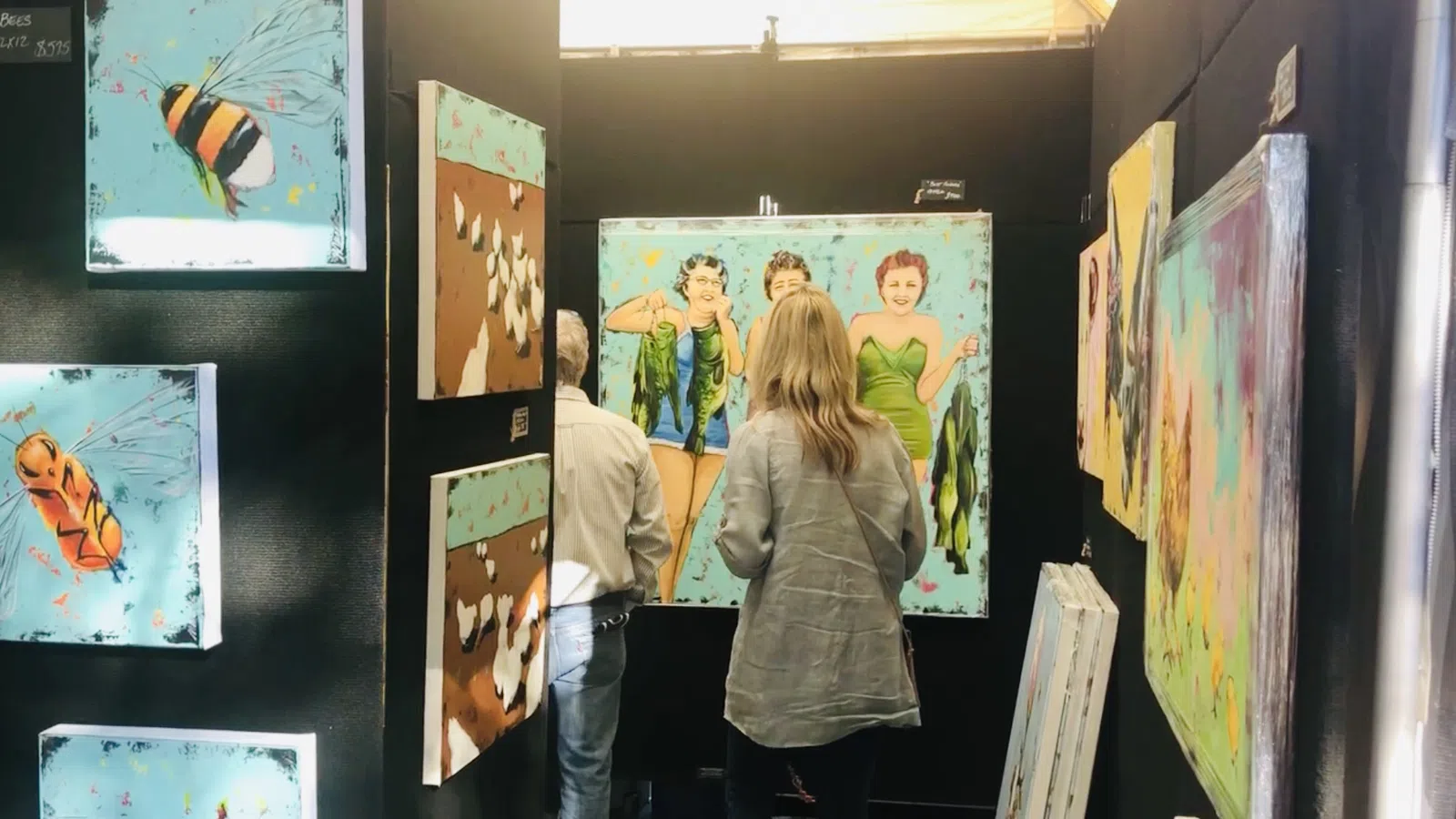 a group of people looking at a wall of art