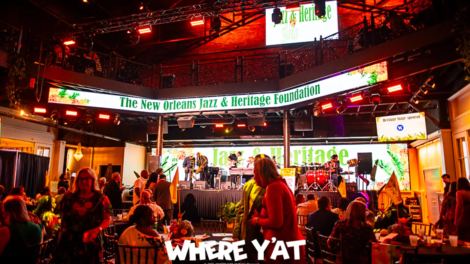 Vibrant stage at the New Orleans Jazz & Heritage Foundation event with musicians performing.
