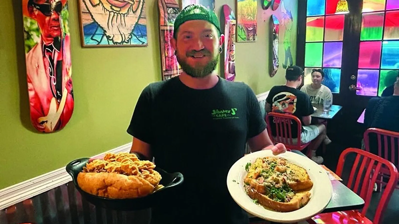 a person wearing a green hat and holding a plate of food