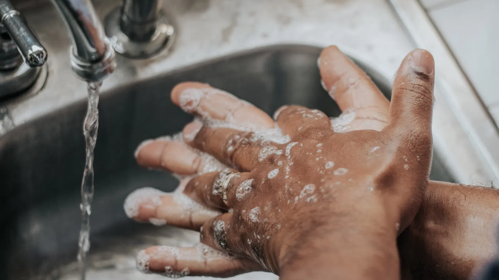 a person washing hands in a sink