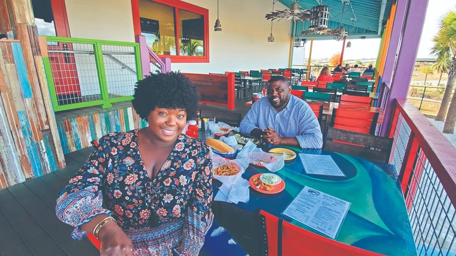a couple of men sitting at a table with food on it