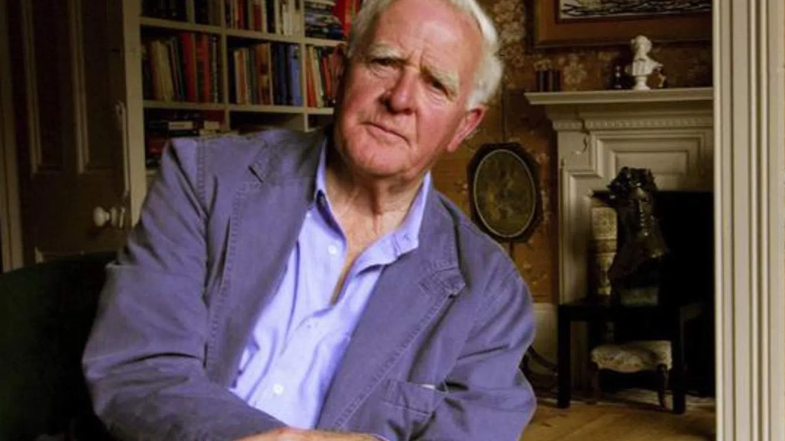 John le Carre sitting in a chair