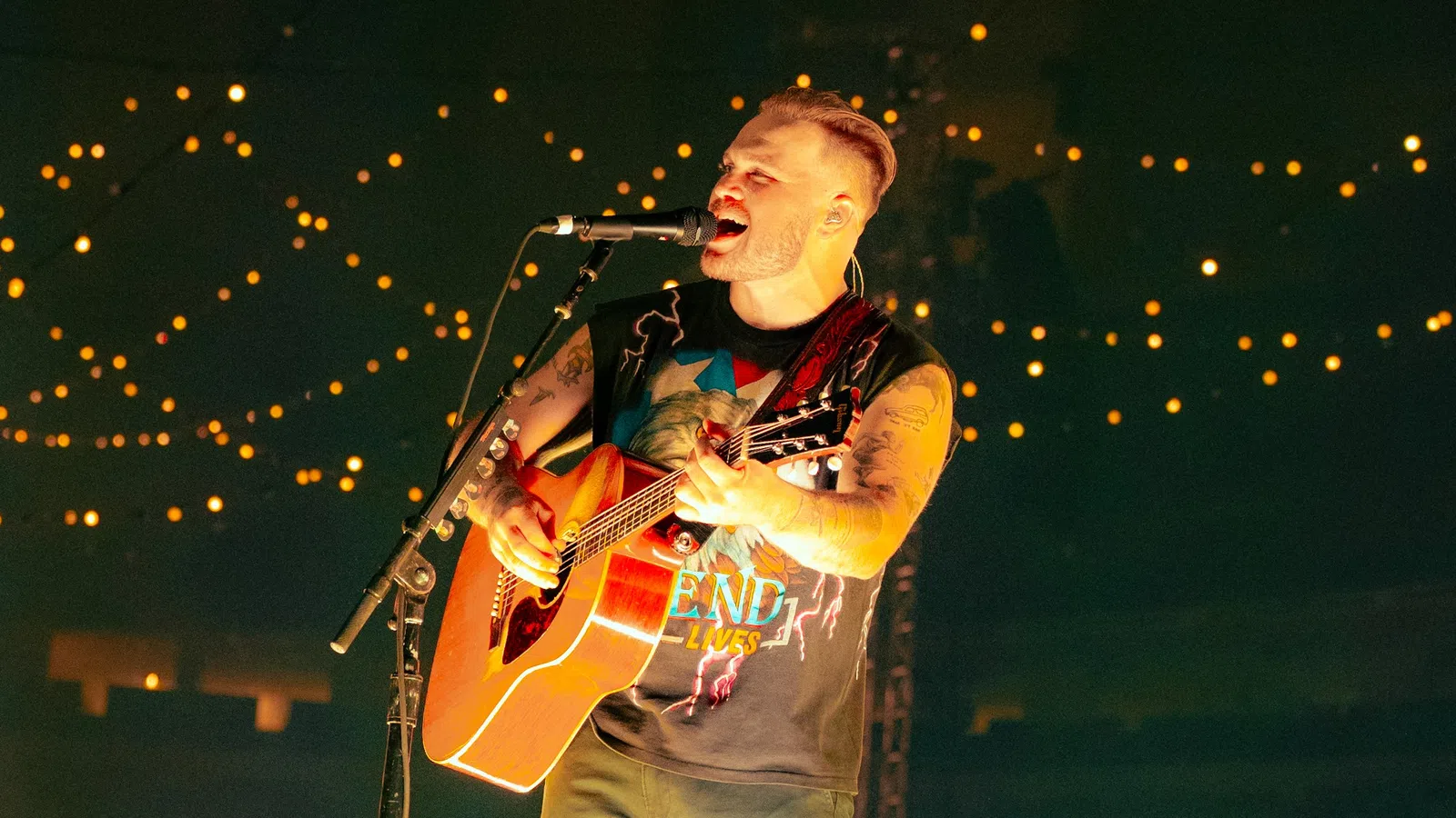 a man playing a guitar on a stage