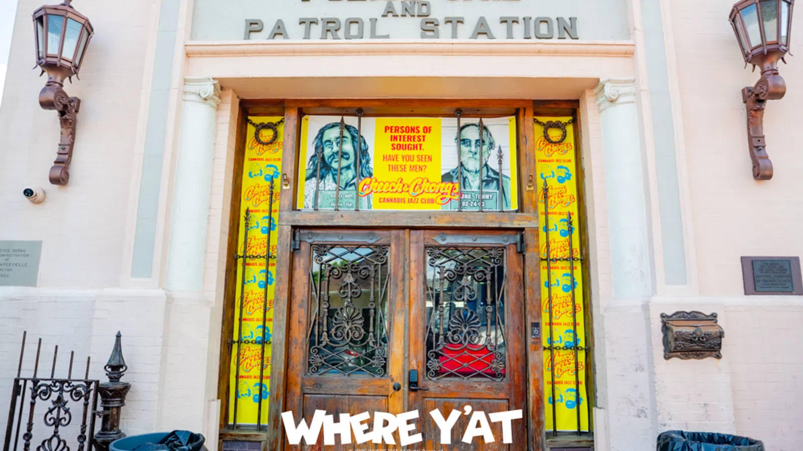 Entrance of police jail and patrol station with wooden doors and colorful posters of persons of interest.