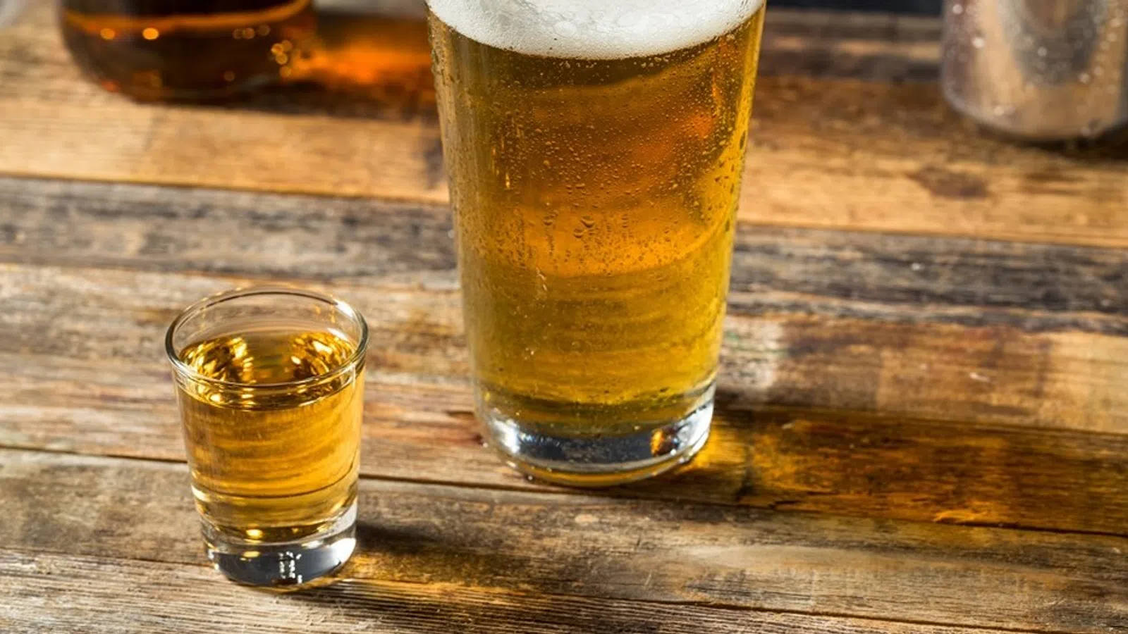 a couple of glasses with liquid in them on a wood table