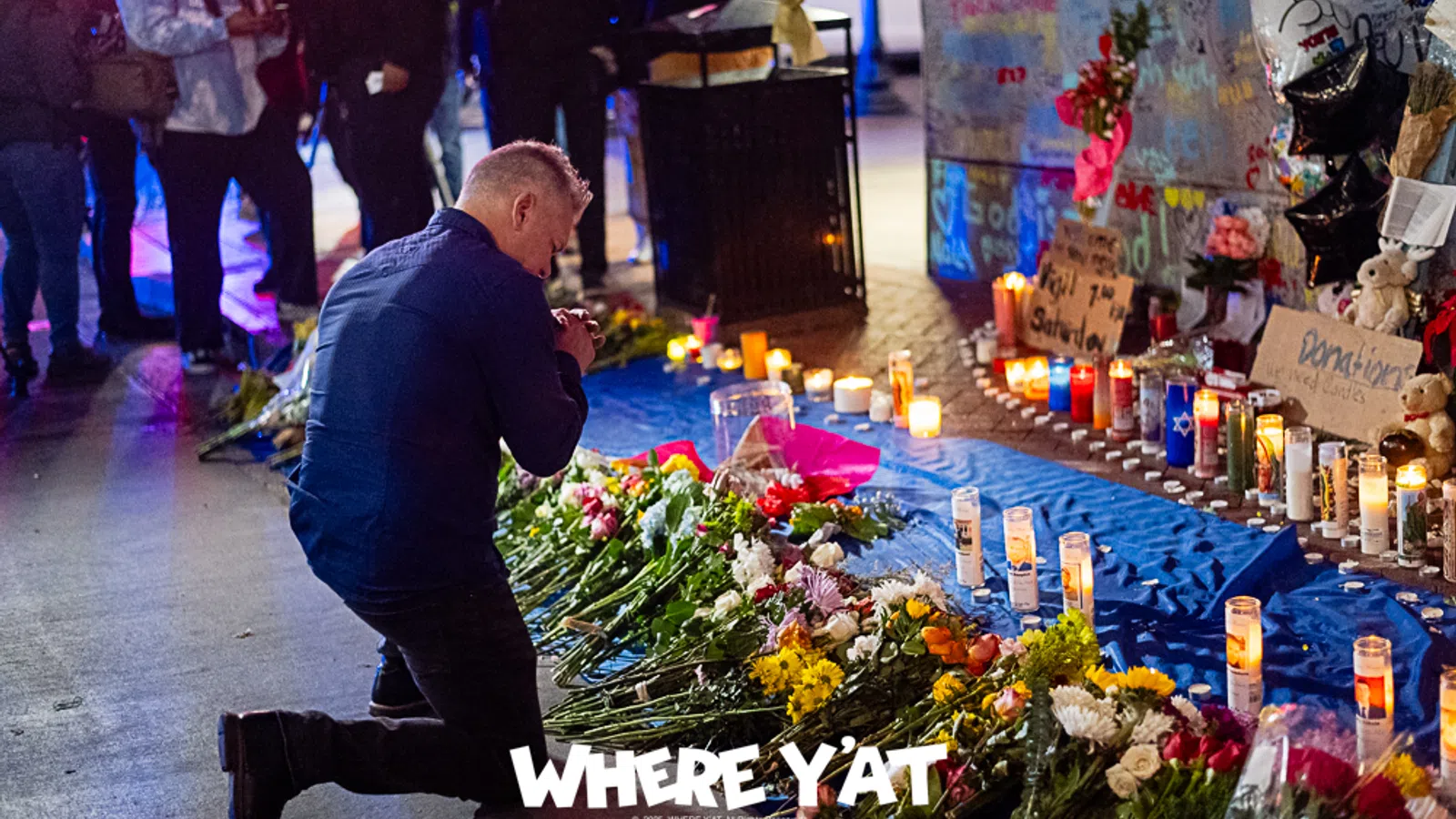 a person kneeling next to a table with flowers and candles