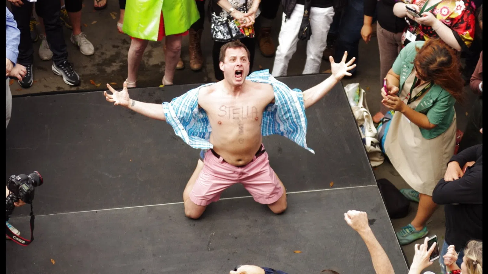 a person with the arms up and legs spread out in front of a crowd