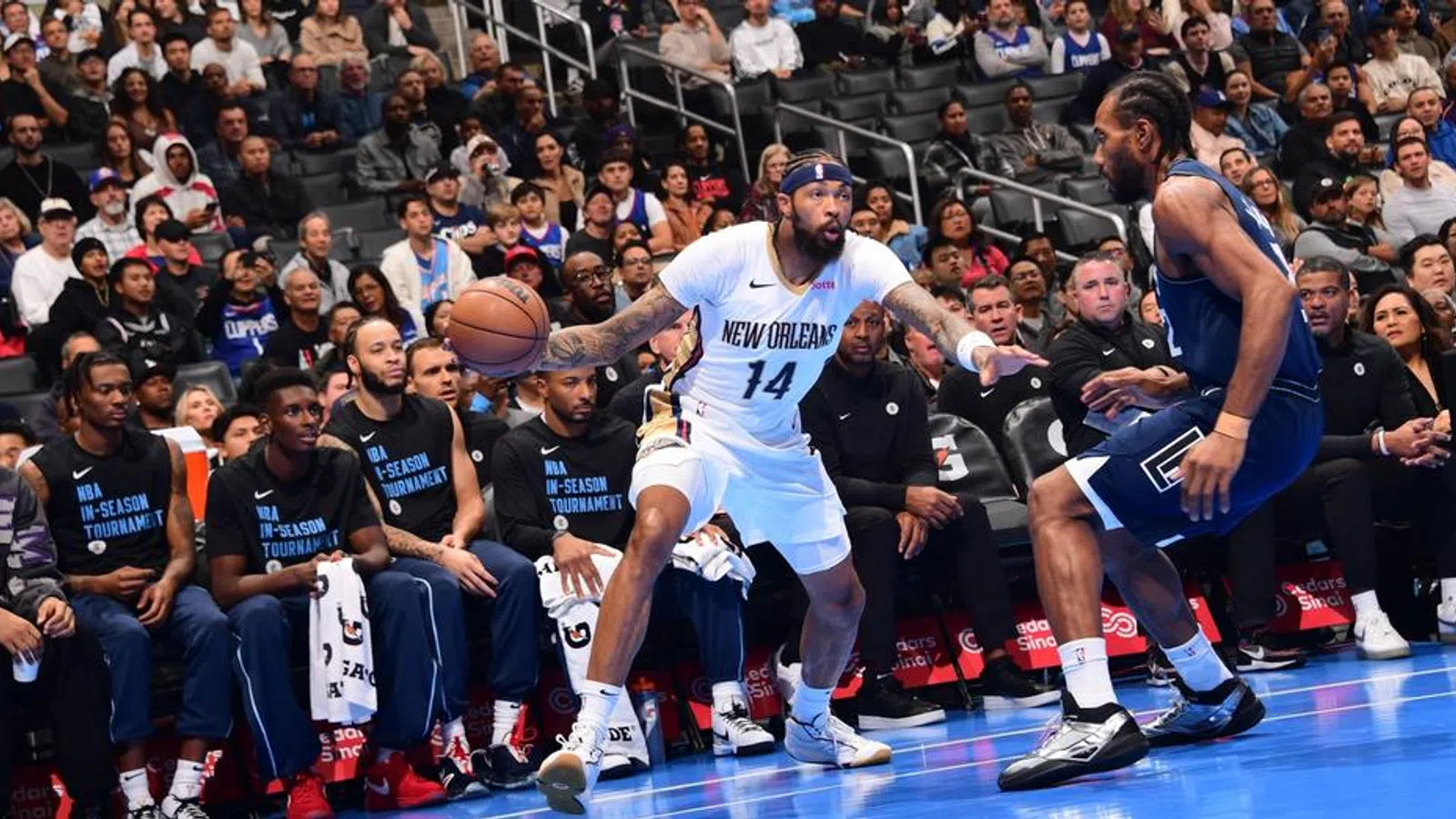 a basketball player dribbling the ball in front of a crowd