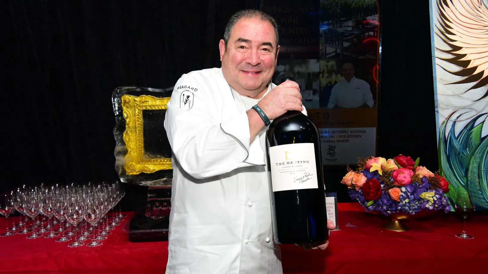Emeril Lagasse holding a bottle of wine