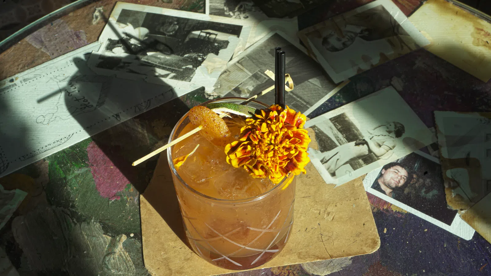 a glass with a straw and a pile of money on a table