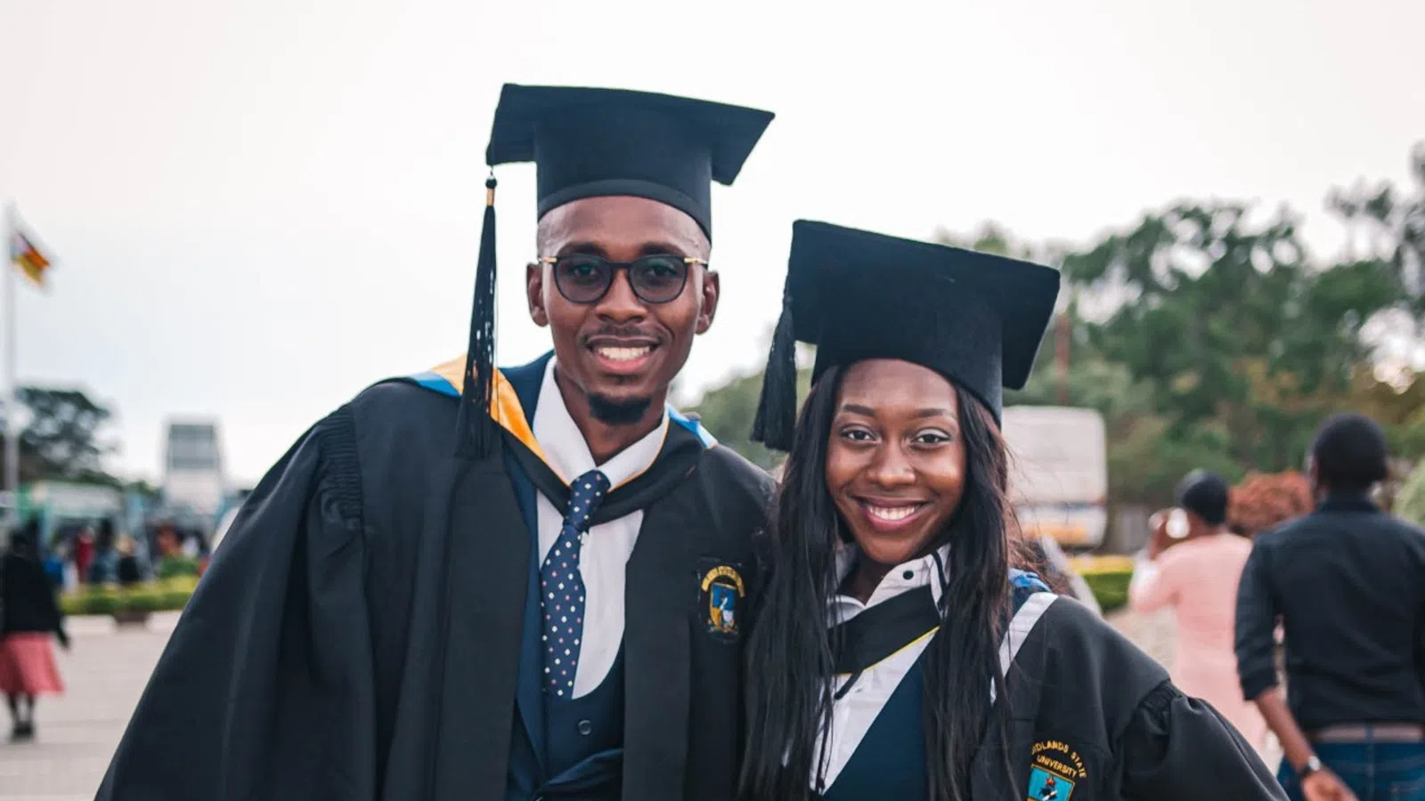 a man and woman wearing graduation gowns and caps