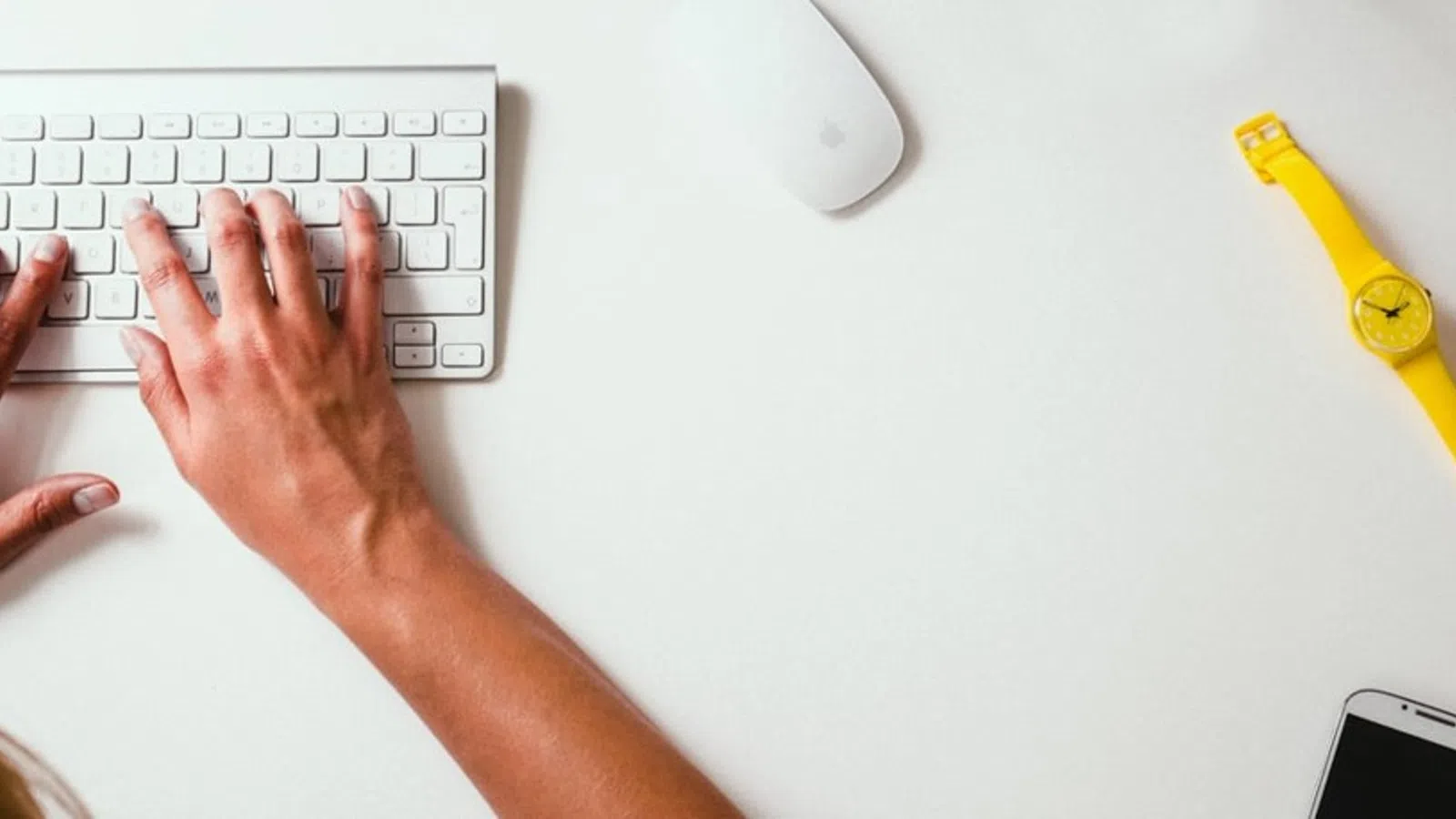 a person's hands on a white surface with a yellow pencil