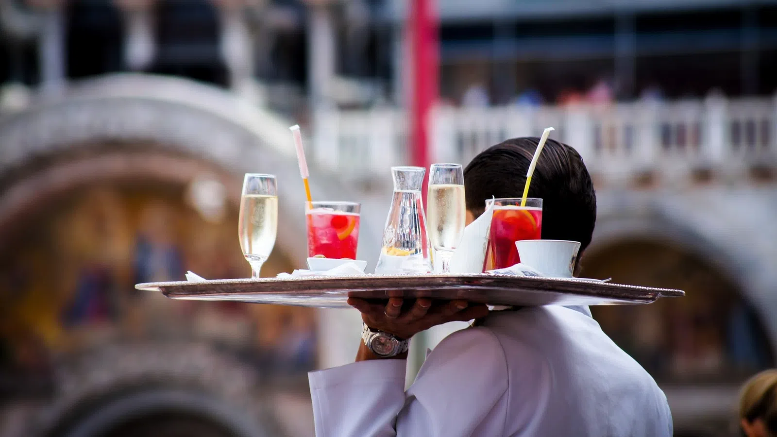 a person holding a tray of drinks
